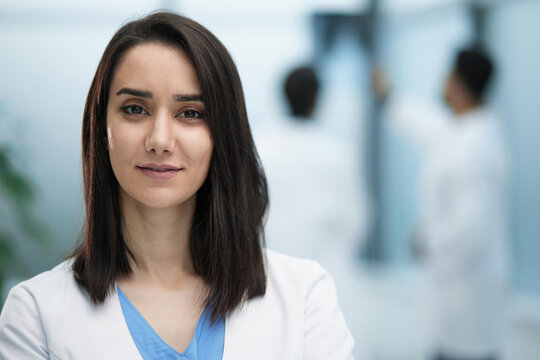 Image of confident female doctor, intern with medical robe, looking confident at camera