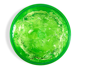 Transparent green cosmetic gel in a round jar. On an empty background.