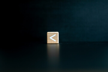 Wooden block written "less than" with a Black background.