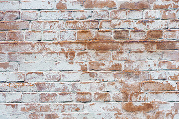 brick wall facade texture texture background. A textured background of decayed old red and white bricks in an exterior uneven wall of a house with dirty whitewashed worn plaster. Brick wall