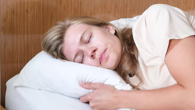 Young woman can not fall asleep , disturbed with uncomfortable pillow or having a nightmare