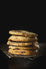 ein Stapel selbstgemachte, hausgemachte Cookies auf Gitterrost. Lecker, frisch, köstlich, appetitlich, vor dunklem Hintergrund im Hochformat