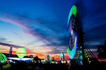 Blurred lights of a carnival ride at sunset at the Creek County fair on Route 66 in Sapulpa,...