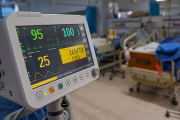 Modern vital sign monitor on patient background at ward in the hospital.