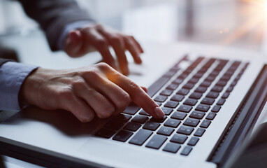 Close-up of male hands using laptop at office