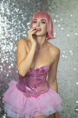 Fototapeta na wymiar Woman in a pink wig with short hair on a silver shiny background