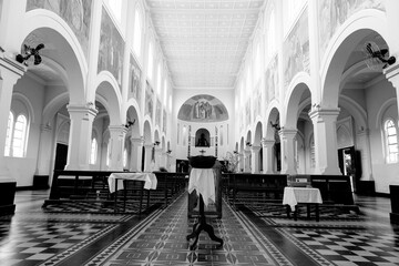 Interior de igreja católica de arquitetura clássica com arco e bancos de madeira.  - obrazy, fototapety, plakaty