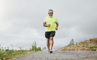 Senior man, running and road in nature, countryside or forest with exercise for marathon, cardio and health mockup. Fitness, training and person walking on path in workout, sport or run in retirement