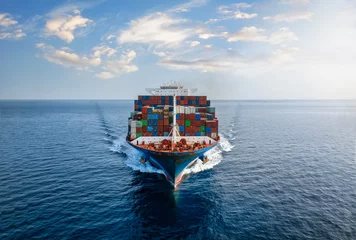 Fotobehang Aerial front view of a large, loaded container cargo vessel traveling over calm ocean © moofushi