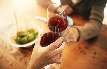 Glasses, closeup and couple with wine, cheers and celebration with lunch, bonding and love. People, man and woman with alcohol, toast or home with achievement, anniversary or marriage with gratitude