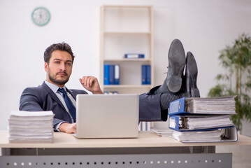 Young male employee and too much work in the office