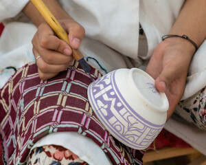 Craftsman painting and decorating colorful ceramic products in pottery factory