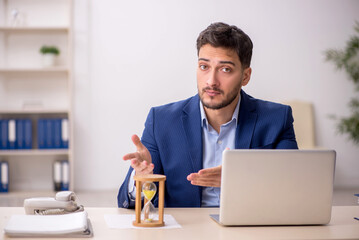 Young male employee in time management concept
