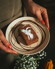 Baker girl with apron holding a Spooky Brownie with ghost art for Halloween in coffee shop