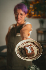 Baker girl with apron holding a Spooky Brownie with ghost art for Halloween in coffee shop