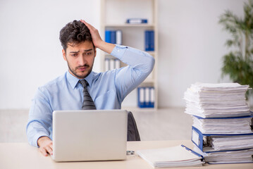 Young male employee and too much work in the office