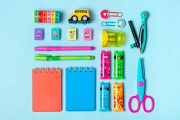 Stationary, back to school, creativity and education concept. Supplies - scissors, pencils, paper clips, note, stapler, calculator, notepad on green background
