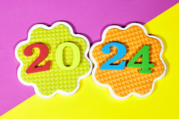 2024 New Year number. colorful sponge digits and design shaped saucer on colorfull background