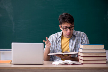 Young male student preparing for exams in the classroom