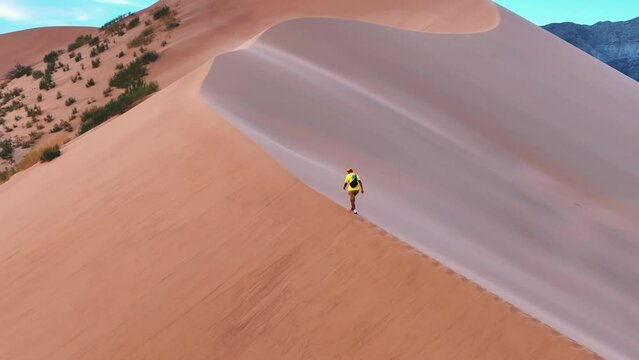 Man walking on the dune of the desert