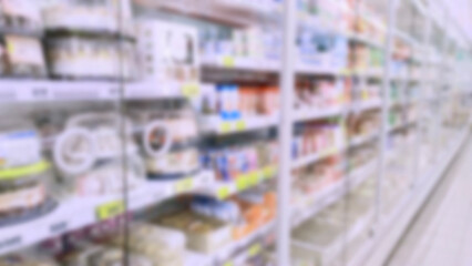 Abstract blur image of supermarket background. Defocused shelves with dairy products, yogurt, cake. Grocery store. Retail industry. Discount. Inflation concept. Aisle. Consumer packaged goods. CPG.