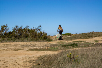 tattooed man with surfboard and bicycle