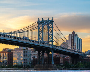 Manhattan bridge is a giant suspension bridge. .The public transport and vehicles drive on two levels. Connecting Brooklyn with Manhattan. Manhattan bridge is over on the East river In New york city - obrazy, fototapety, plakaty