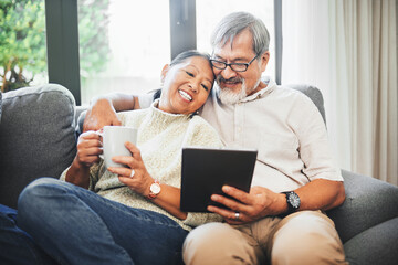 Tablet, coffee and senior couple on sofa bonding, relaxing and networking on social media together. Happy, digital technology and elderly man and woman in retirement scroll on mobile app or internet.