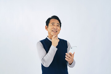 スマホを見ながら考えるミドル男性