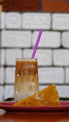 a slice of cake and a glass of cold coffee