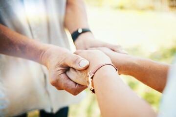 Holding hands, closeup and couple in park, sunshine and care with bonding, faith or pray in nature....