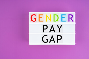 Lightbox displaying the text "Gender Pay Gap" on purple background. Gender differences concepts.