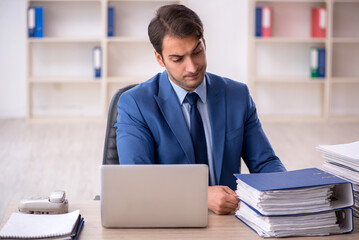 Fototapeta premium Young male employee and too much work in the office