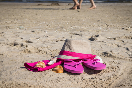 Different accessories using for relax on beach. Straw hat, flip flop and towel. Summertime