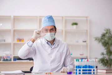 Fototapeta premium Young male chemist working at the lab