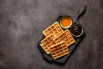 Homemade Belgian waffles on a dark background. Top view, flat lay.