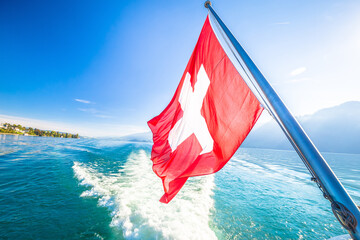 Switzerland flag on boat flowing Luzern lake - obrazy, fototapety, plakaty