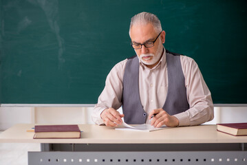 Old male teacher in the classroom