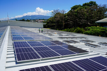View of the installation of solar panels on a warehouse roof -green energy - renewable energy 