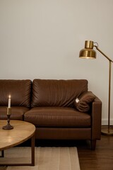 dark living room with a brown leather capitone sofa and a classic bronze floor lamp