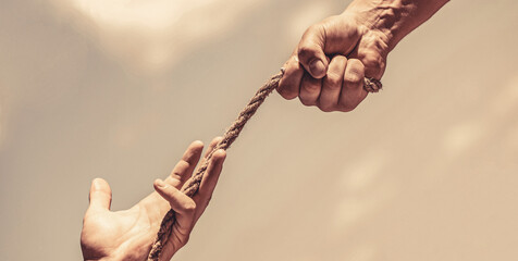 Rescue, help, helping gesture or hands. Conflict tug of war. Rope, cord. Hand holding a rope,...