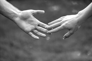 Female and male hand together. Couple holding hands in the Park. Hold on, hands, couples. Couple hold hand in the autumn or summer park. Black and white