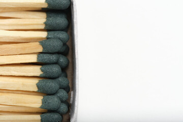 Matches with green head in box on white background.