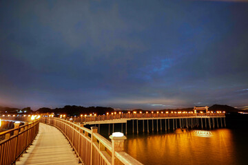 The beautiful walk way lighting through a river in an evening twilight