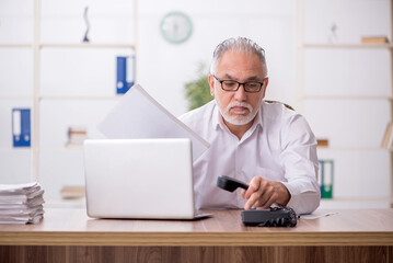 Old male employee working in the office