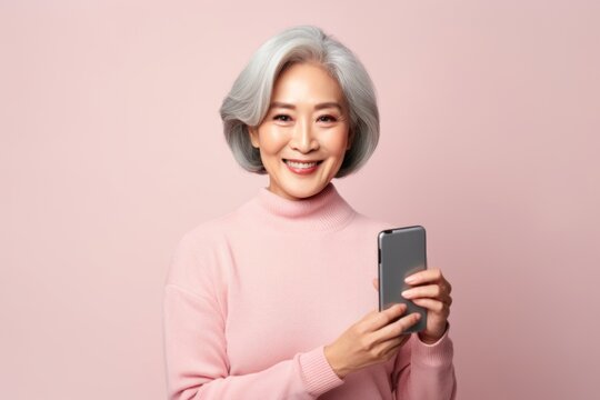 A woman with grey hair holding a cell phone. Can be used to depict technology, communication, or modern lifestyle.