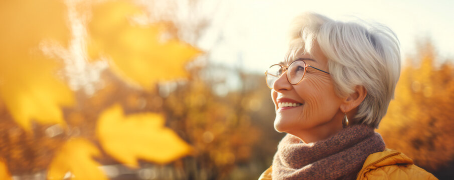 A happy elderly woman laughing in a park in autumn