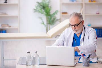 Old male doctor in telemedicine concept