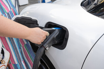 Woman Charging Battery of Electric Car