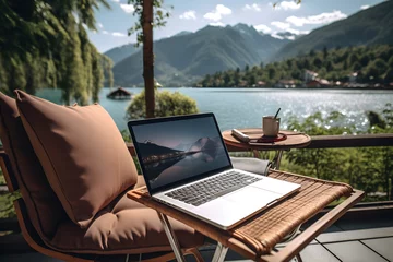 Fotobehang Laptop computer on a terrace with beautiful lake view background, Digital nomad’s lifestyle,  Remote job and teleworking concept, Vacation Leave, Nomad visa © rabbizz77